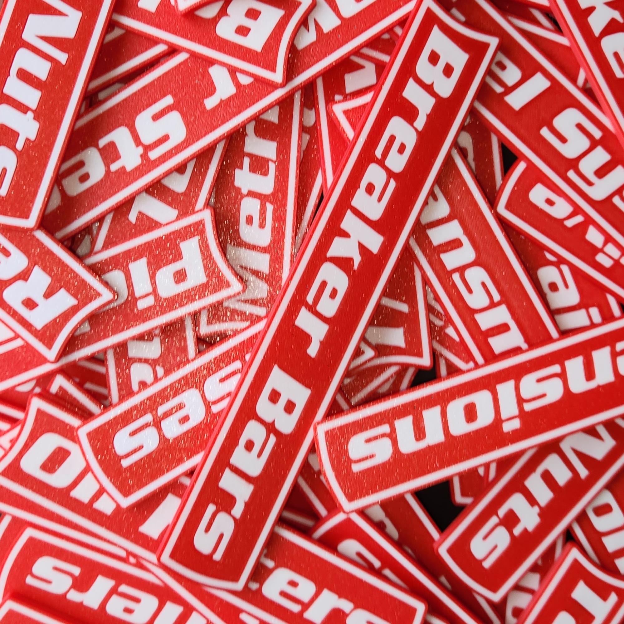 A pile of VoltariTek red labels showing the white-on-color visual system